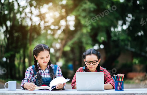 Preview: Two students studying together online with a laptop in the park