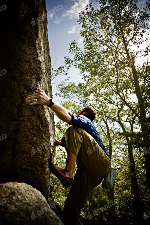 Preview: Bouldering,a climber climbing steep cliffs in the woods near Essex, Massachusetts, free climbing.