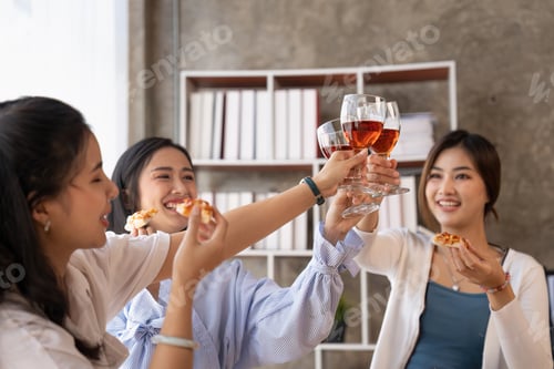 Preview: Group of Asian friends gather to celebrate Christmas with champagne and eating pizza at home. Joy