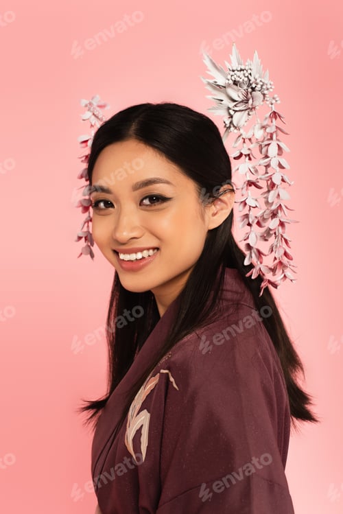 Preview: Pretty asian woman in oriental wear looking at camera isolated on pink