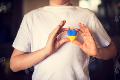 Preview: the guy holds a yellow-blue heart in the color of the flag of Ukraine near the sternum
