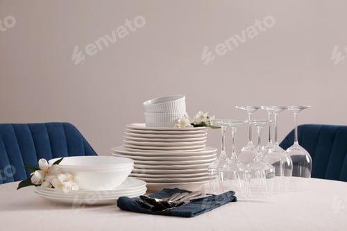 Preview: Set of clean dishware, cutlery and wine glasses on table indoors