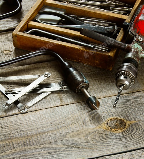 Preview: Drills in box, drill, chisel on a wooden background.