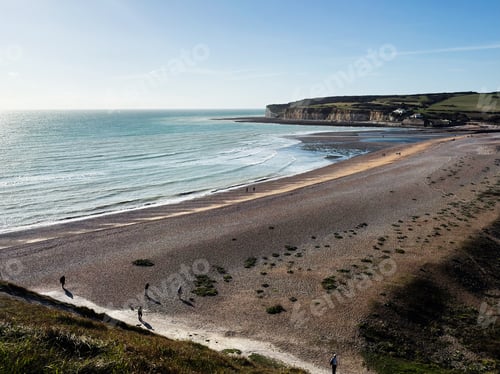 Preview: Tranquil coastal scene at Seven Sisters Cliffs in East Sussex with people on the beach