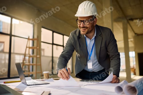Preview: Happy project manager working on blueprints at construction site.