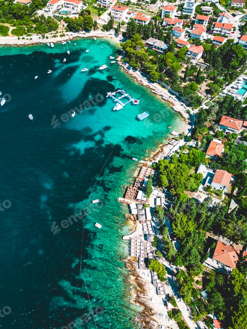 Preview: Charming tropical island town with turquoise waters in the foreground and boats in the background