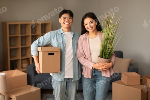 Preview: Joyful Chinese Couple Posing With Carton Boxes And Plant Indoor