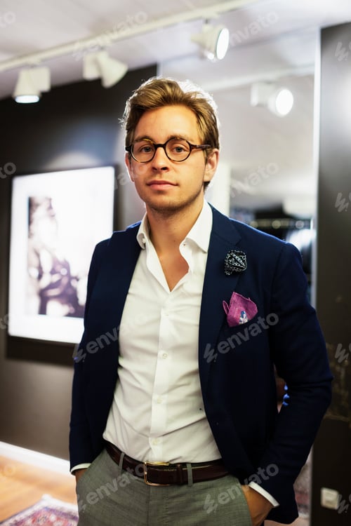 Preview: Portrait of handsome fashion designer standing with hands in pockets at showroom