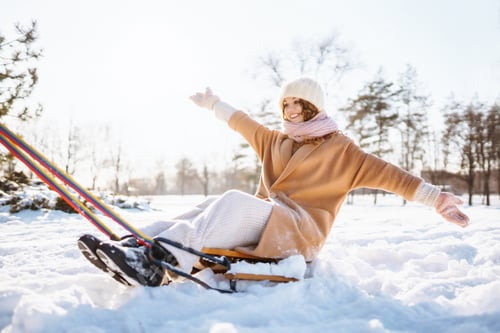Preview: Young woman rolls on a sled in the winter snowy forest. Nature, holidays, rest, travel concept.