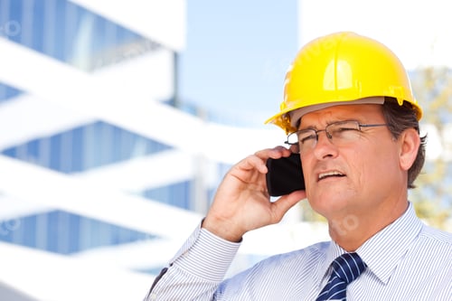 Preview: Focused Construction Worker Talking on Cellphone Outdoors