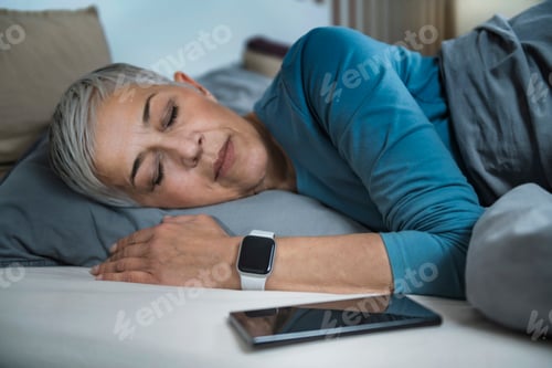 Preview: Sleep Apps - Tech-savvy Senior Woman Sleeping in Bed
