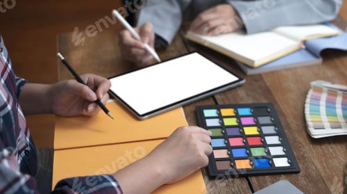 Preview: Two artists working on tablet, colour paper tone on workspace at the office