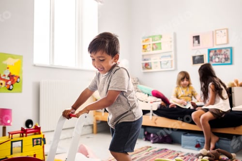 Preview: Cheerful Child Plays with Toy Cart in Bedroom