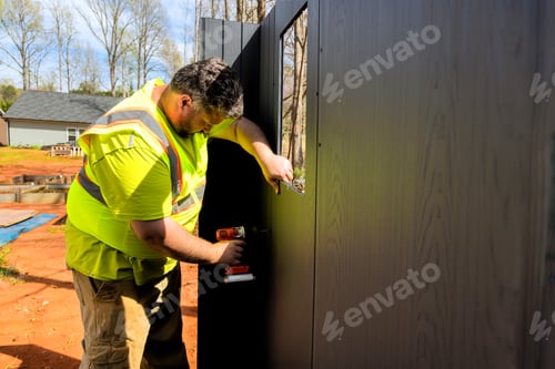 Preview: Worker constructs exterior wall at construction site during assembling storage shed
