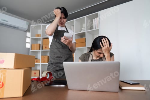 Preview: Stressed Couple Analyzing Stock Market Data Online at Home with Laptop and Smartphone