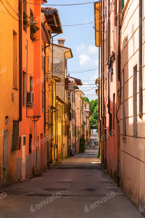 Preview: View of scenic narrow street with traditional houses in an old town in Europe with blue sky