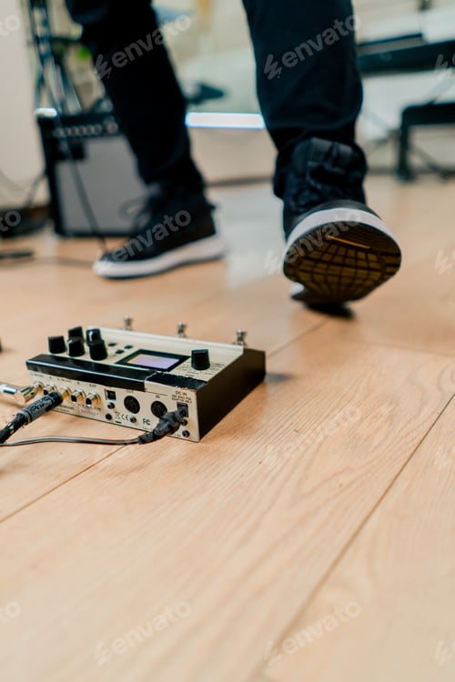 Preview: musician's male foot pressing bass drum pedal or bass electric guitar in recording studio close-up
