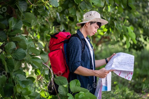 Preview: Young backpacker man looking map while working in trip