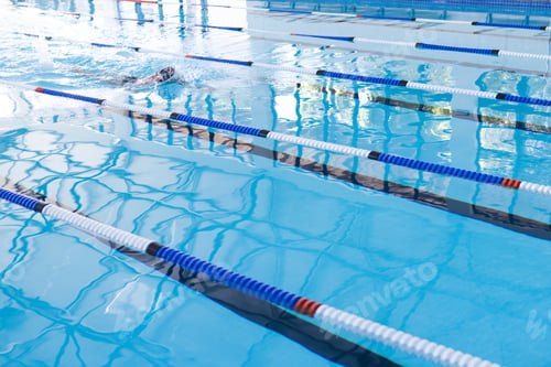 Preview: Swimmer in action at a competitive pool event, with copy space