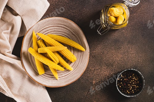 Preview: Canned mini corn cobs on a plate on a table top view