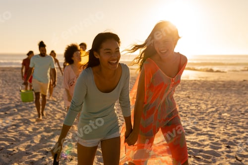 Preview: Mixed race friends group walking on beach