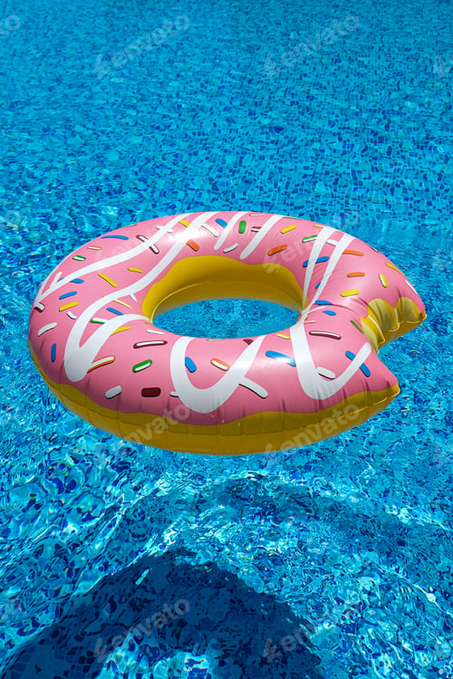 Preview: pink inflatable donut doughnut floating mattress in swimming pool. Beach pool accessories.