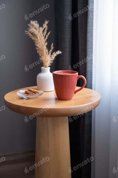 Preview: Cozy coffee setup with cookies and dried flowers on wooden table in living room.