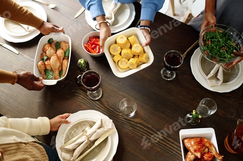 Preview: Above angle of hands of family members putting homemade food on table