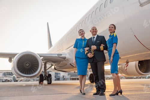 Preview: Smiling Pilot and Attendants Beside a Passenger Plane