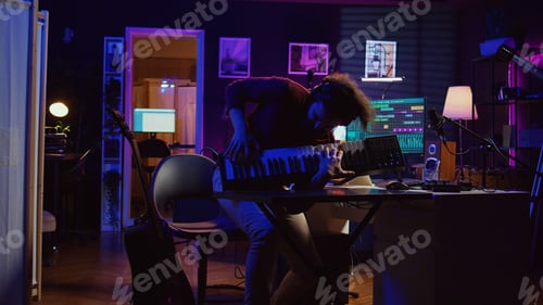 Preview: Energetic confident artist playing electronic piano in home studio