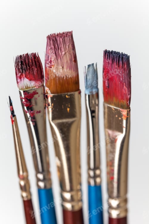 Preview: Paint brushes in oil isolated on off-white background, closeup