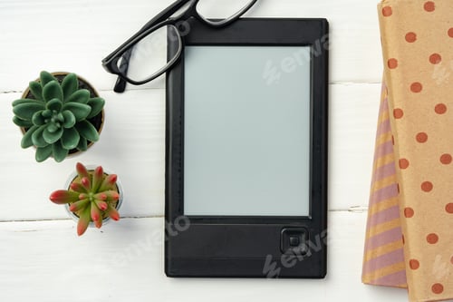Preview: Portable e-book reader on wooden background top view