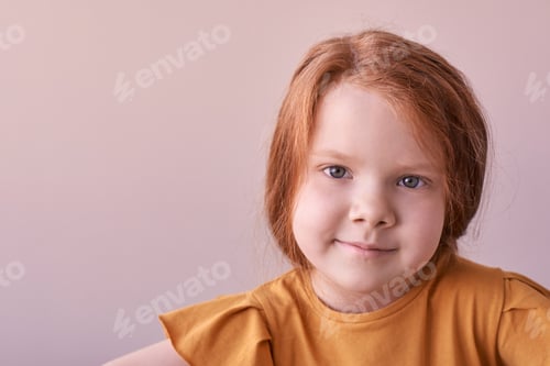 Preview: Young caucasian female child with red hair smiling in brown shirt against neutral background