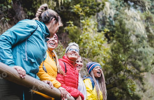 Preview: Multiracial women having fun exploring nature on trekking day in mountain forest