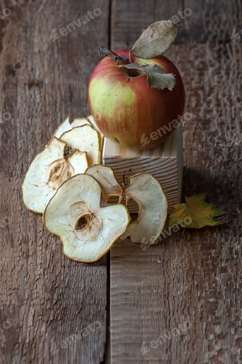Preview: Apple and apple chips on an old wooden table.