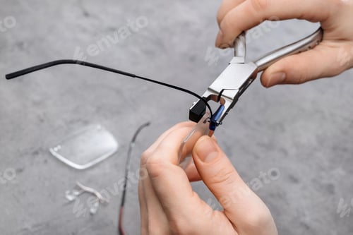 Preview: Closeup of optician fixing glasses frame with special pliers