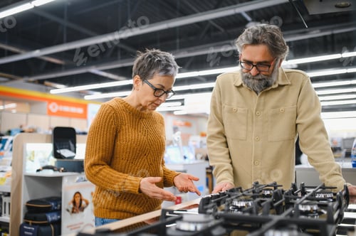 Preview: Senior couple choosing gas stove in electronics store
