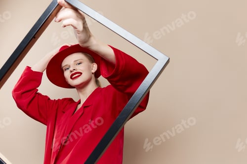 Preview: fashionable woman with wooden frame posing red suit beige background