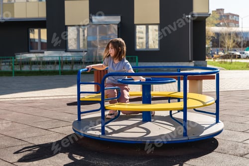 Preview: cute girl walks and whirls on the carousel outdoors