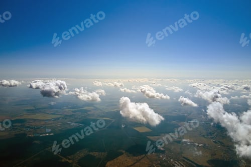 Preview: Aerial view from high altitude of earth covered with white puffy cumulus clouds on sunny day