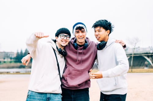 Preview: Multiethnic students hugging, smiling outdoors, expressing friendship and joy during college life