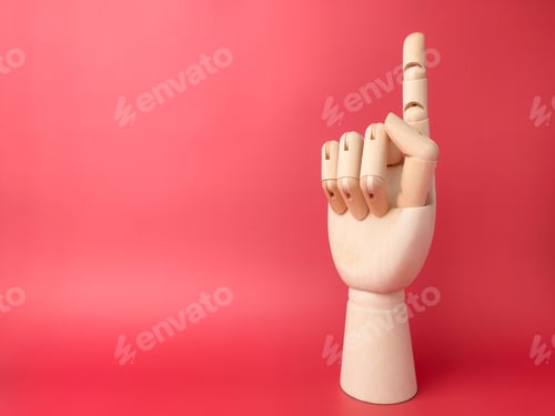 Preview: Wooden hand that is showing a one -finger gesture on a red background with copy space