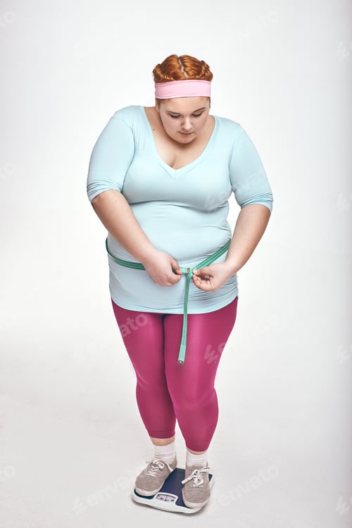 Preview: Chubby woman is measuring her belly on white background