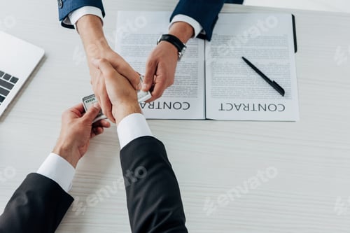 Preview: top view of man giving money and shaking hands with business partner