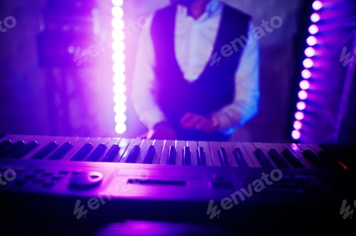 Preview: Hand of keyboardist on stage with lights.