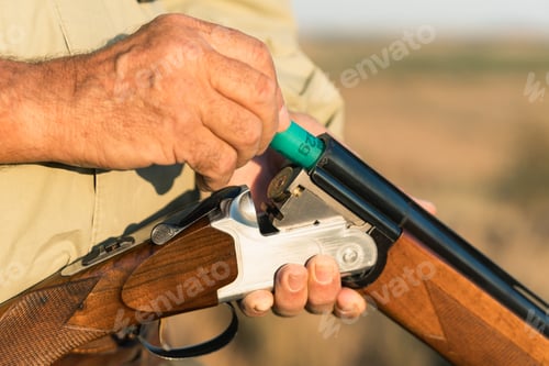 Preview: Hunter loading shotgun shell for sport hunting outdoors