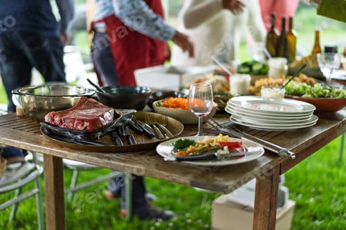 Preview: Outdoor barbecue party with steak and salads on rustic wooden table