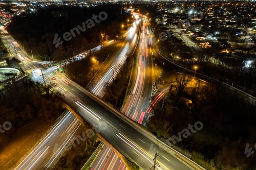 Preview: Aerial view of a long exposure shot of illuminated roads, with a cityscape in the background