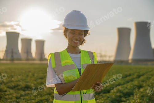Preview: Female engineer constructor stands with clipboard on field on industrial enterprise background