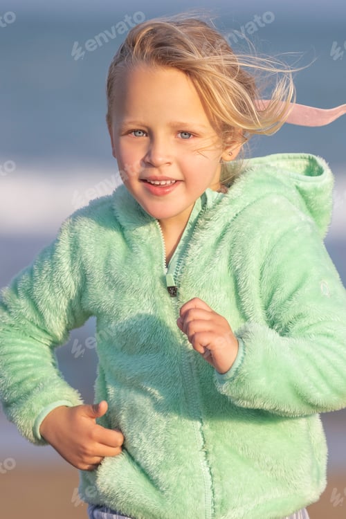 Preview: A 5-year-old girl in a green jacket is running